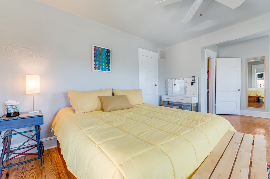 Bedroom 1 has sunny yellows and a comfy King Bed.