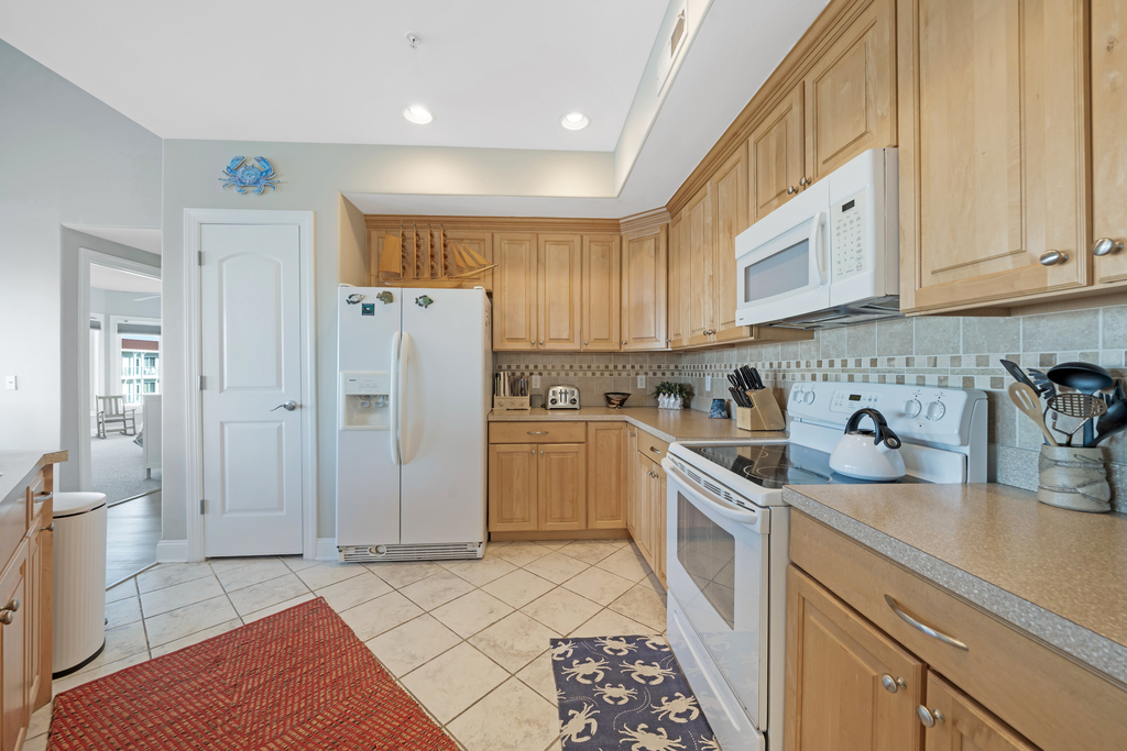 Warm wood cabinetry and tile flooring in the Kitchen.
