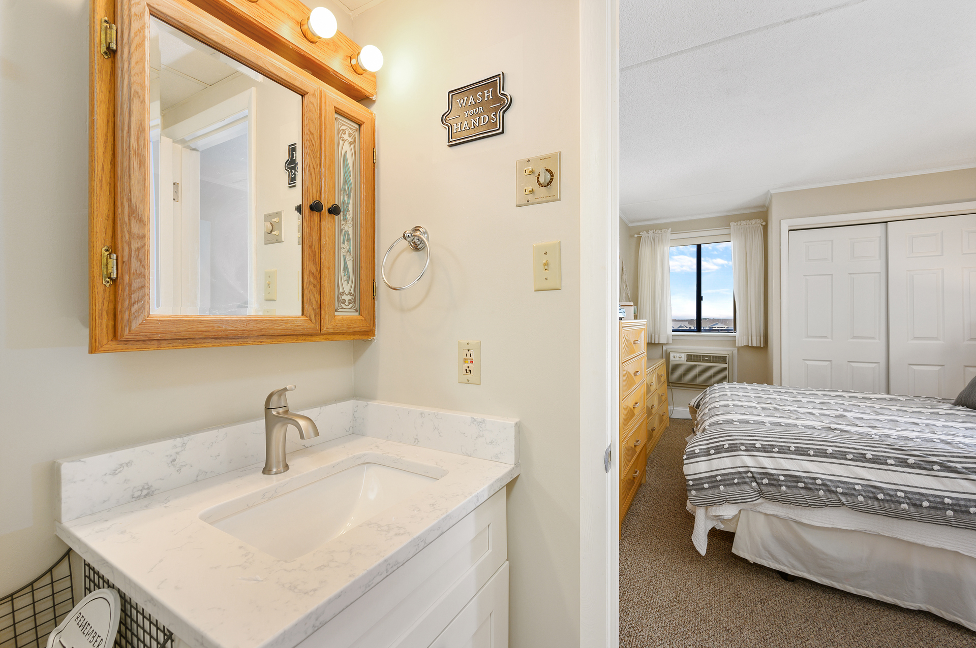 A sleek bathroom opens to a serene bedroom, uniting elegance with cozy charm.