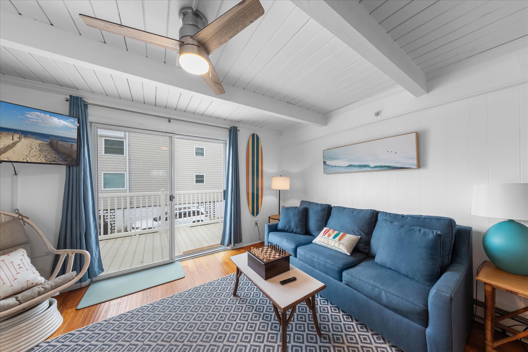 This sitting area offers a sleeper sofa and balcony access.