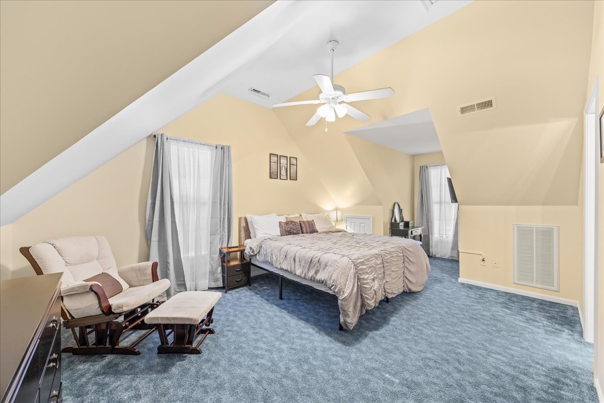 Upstairs, Bedroom 2 has a luxurious King Bed and sunny yellow walls.