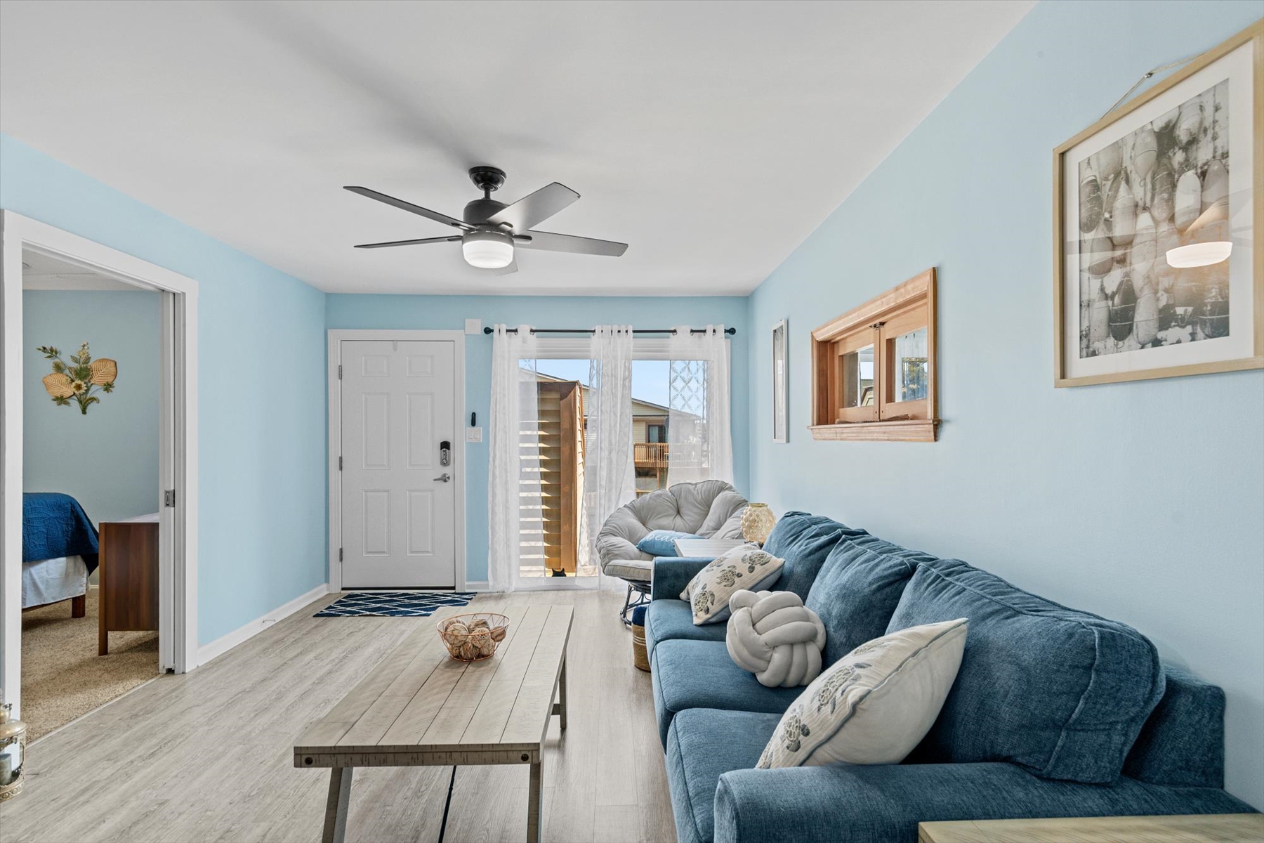 Soft wall colors and light hardwood-style floors tie the inviting living area together perfectly.