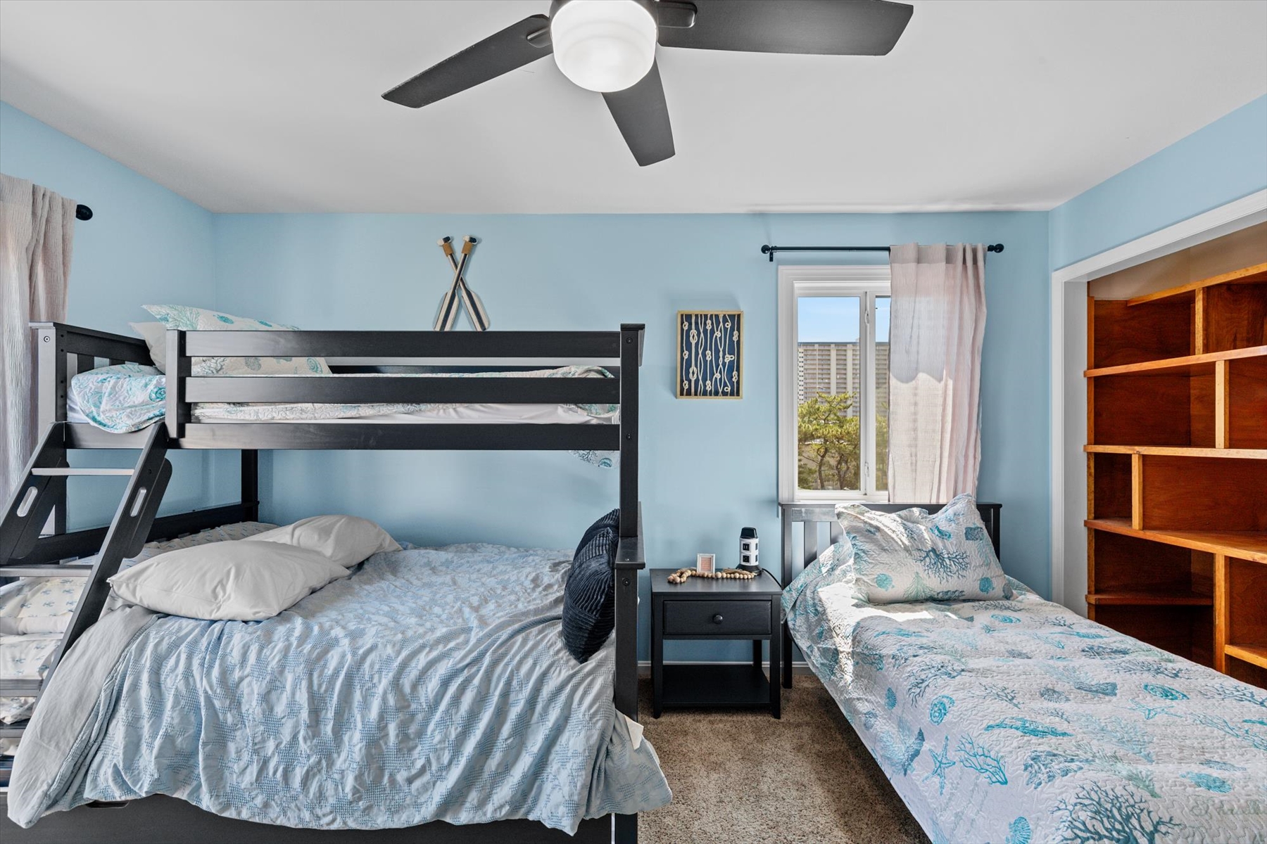 Perfect for the kids or extra guests, this room features comfortable bedding, bedside storage, and a large ceiling fan for added comfort.