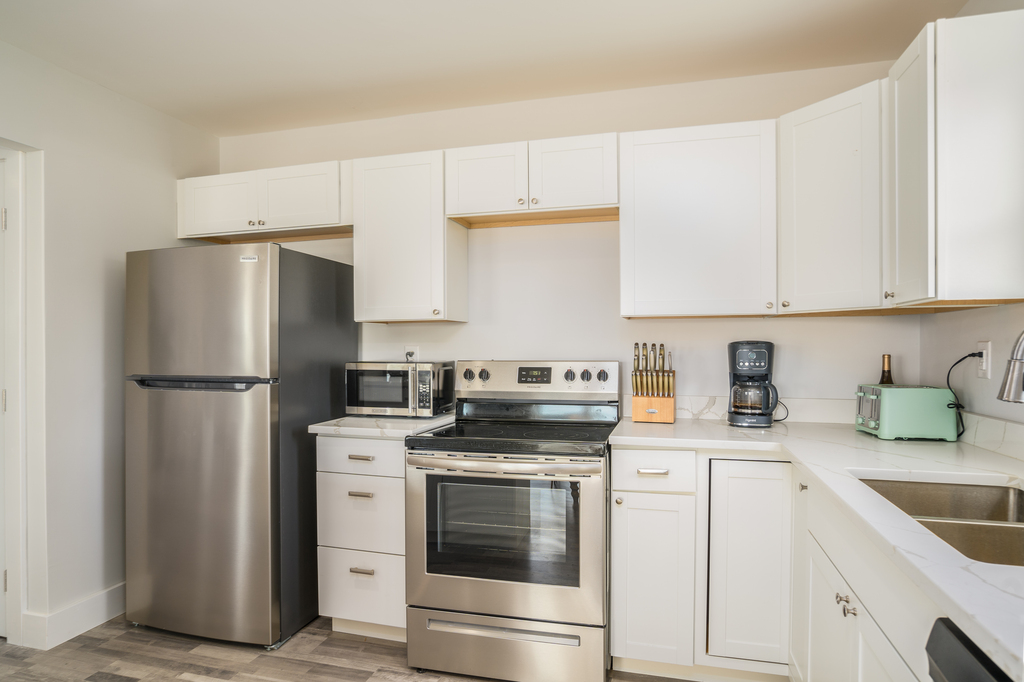 Stainless Appliances and beachy White Cabinetry.