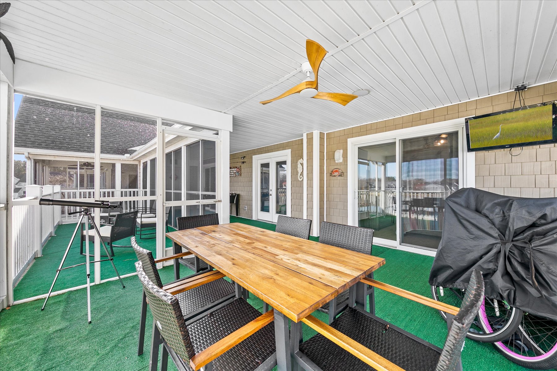 Your covered outdoor dining area offers perfect spots for meals and relaxation, complete with comfortable seating and a ceiling fan for those warm days.