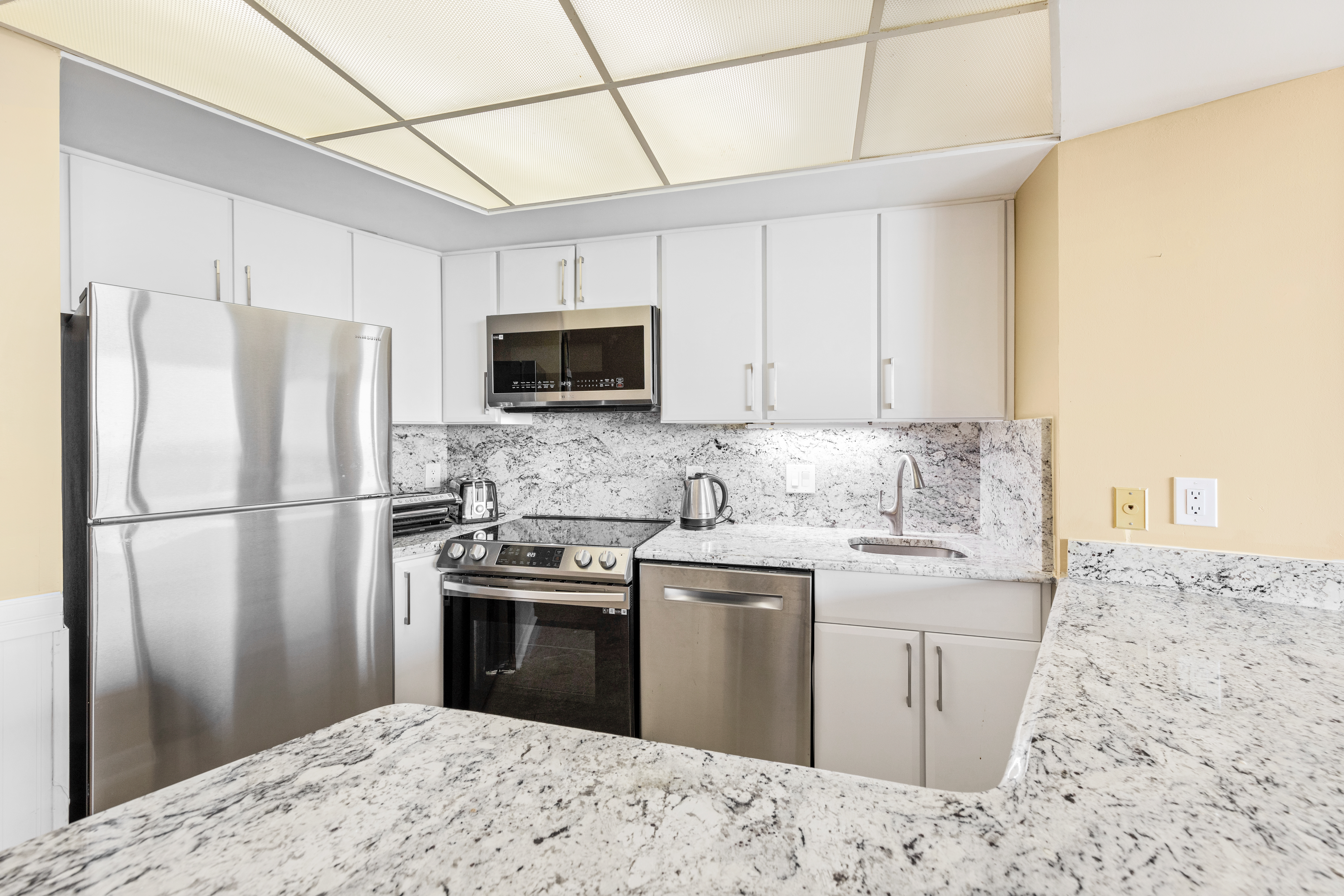 The kitchen has been updated with bright white cabinets and granite countertops.