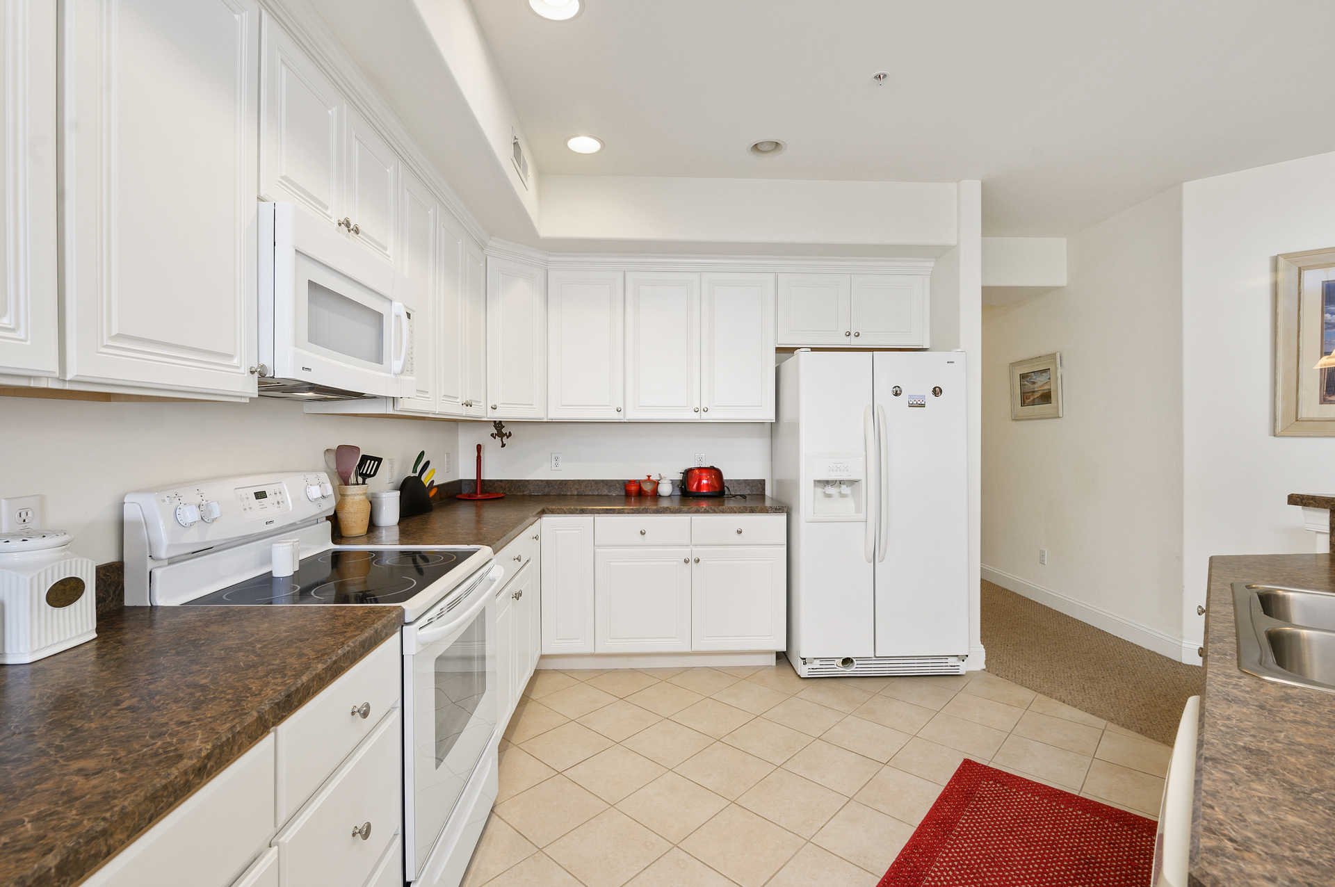 Gleaming Granite and beachy white Cabinetry.