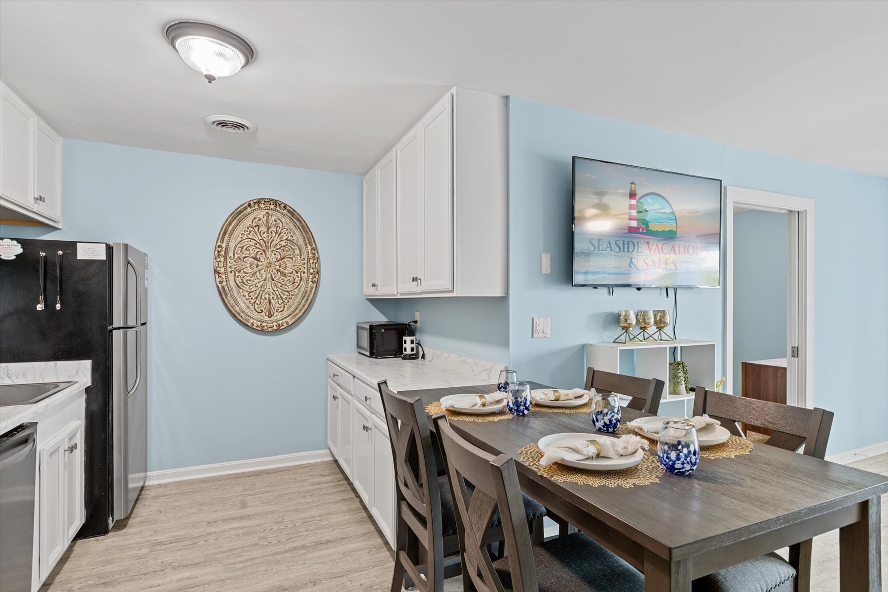 A side view highlights the convenient flow between the dining table set and the white kitchen cabinetry.