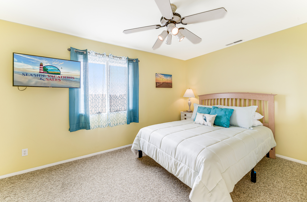 Bedroom 1 has sunny yellows and a comfy Queen Bed.