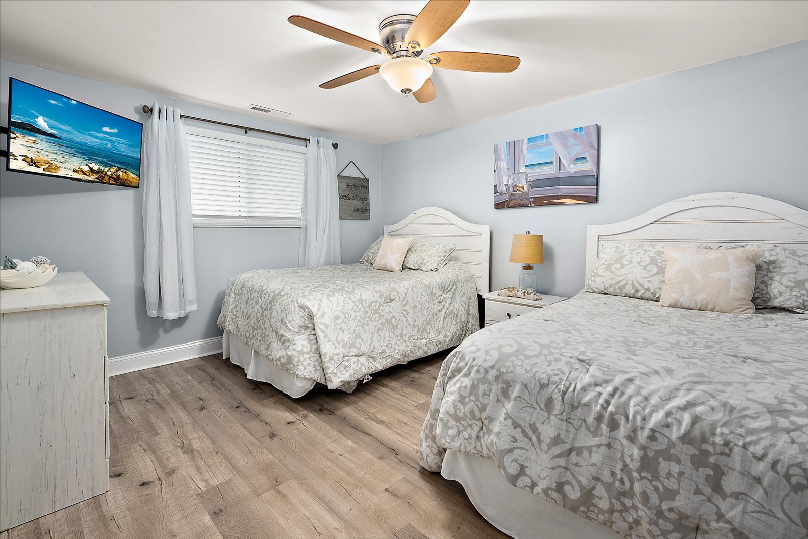 Perfect for families or groups, this bright and comfortable bedroom features two cozy beds and a cooling ceiling fan.