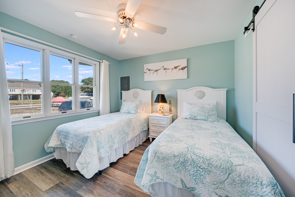 Bedroom 2 is adorned in colors of sea glass, and has 2 Twin Beds.