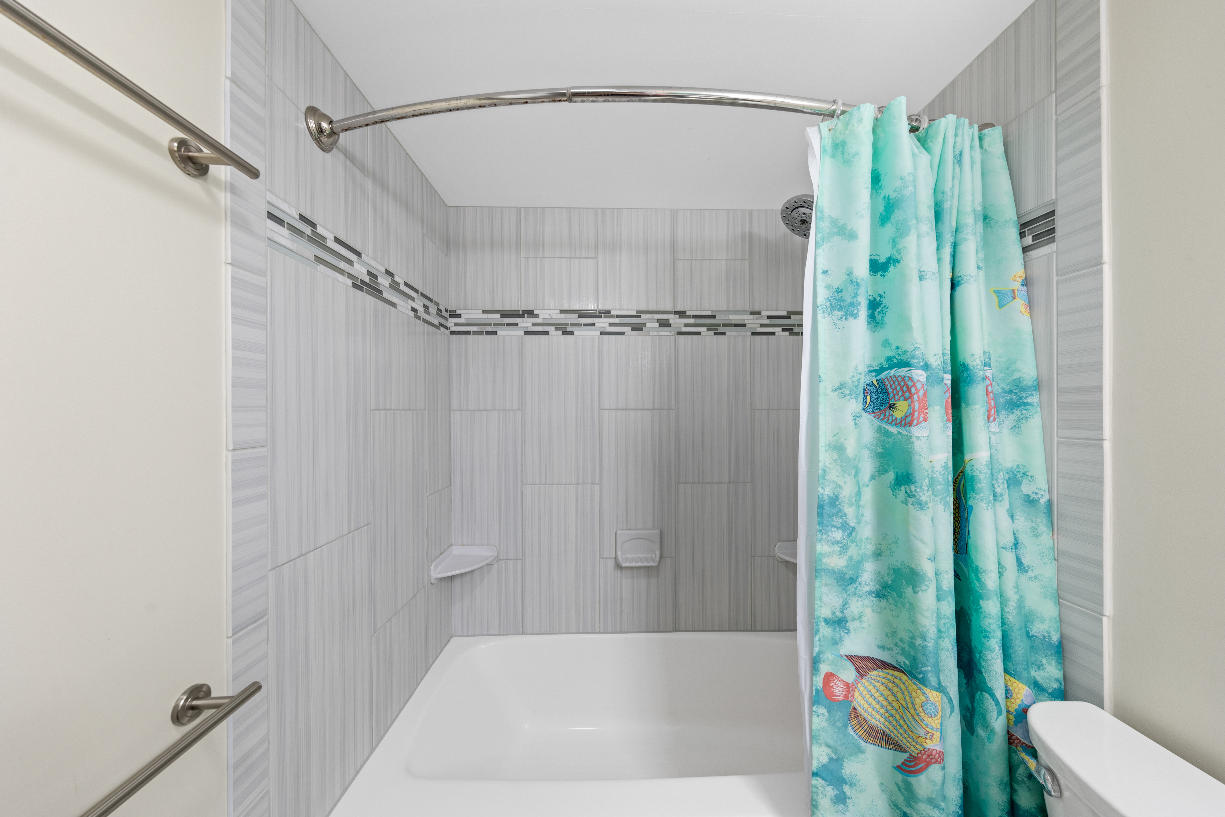 Shower away all the sand from your beach day in the tiled shower/tub combo.
