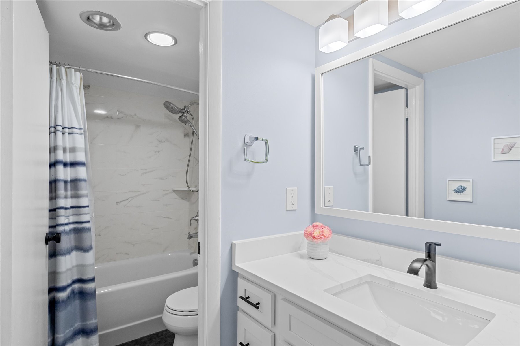 Beautifully lit, the shared Bath has a Shower/Tub combo.