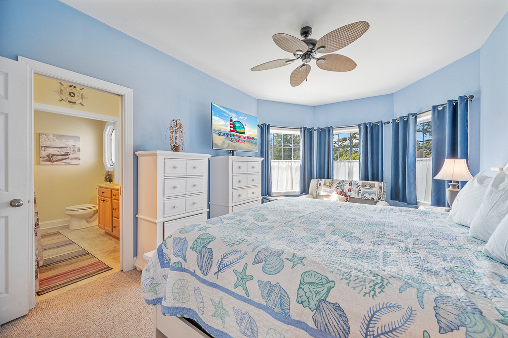 Beachy blues and Flat Screen TV in Primary Bedroom 1.