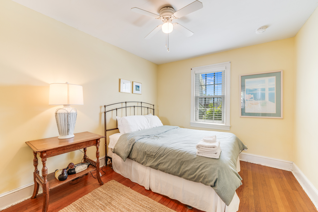 Downstairs Bedroom 1 has a Queen Bed and Sunny Yellow Walls.