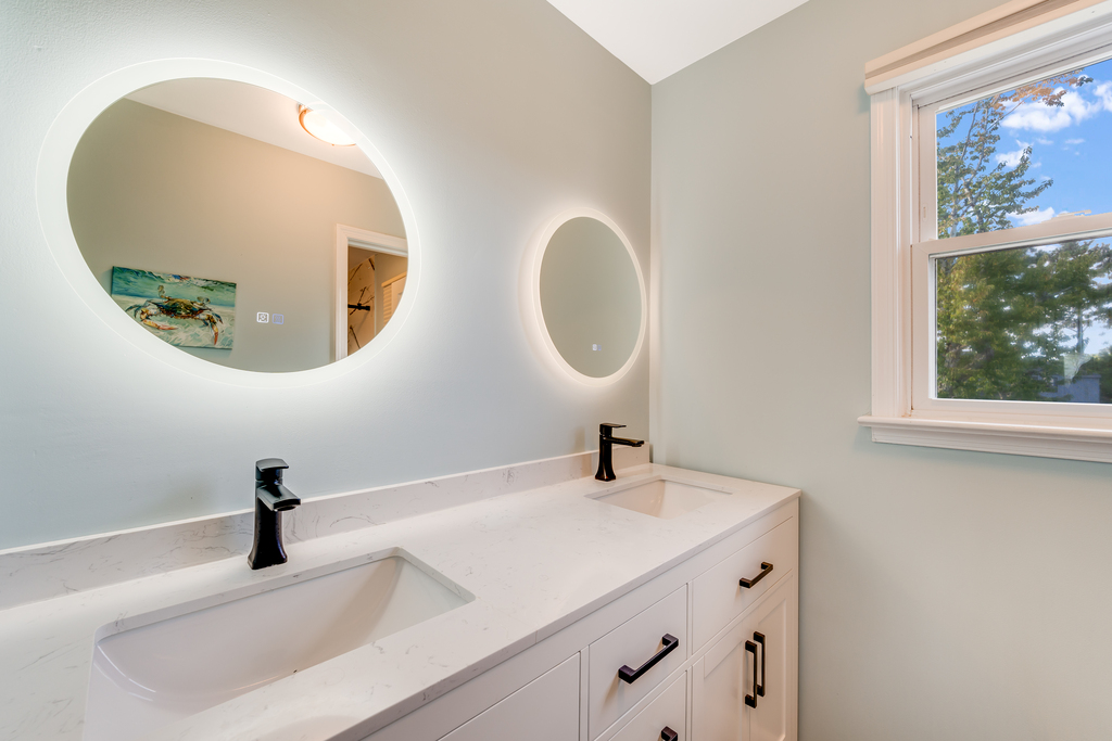 Spa-like Primary Bathroom with Double Vanity and backlit Mirrors.