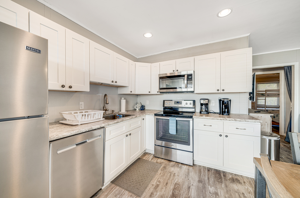 Stainless Appliances and beachy white cabinetry.