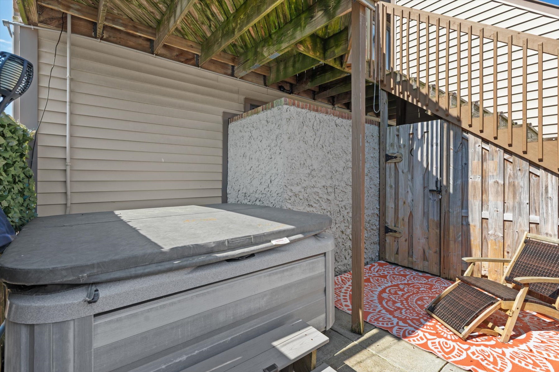 The private lower patio features a secluded hot tub, securely covered and ready to help you soak your cares away.