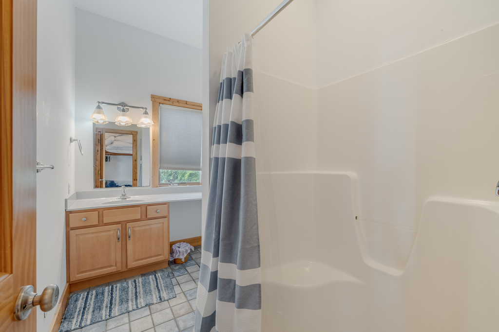 Attached Full Bath 1 is dressed in beachy blues and has a Walk-in Shower.