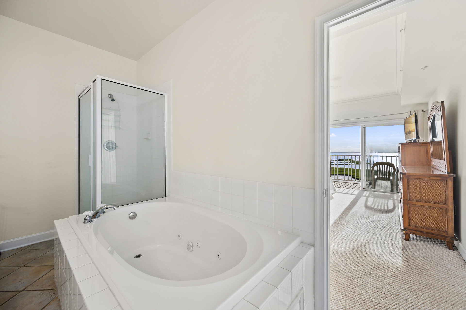 the attached en suite bathroom has a large soaking tub as well as a glassed in shower