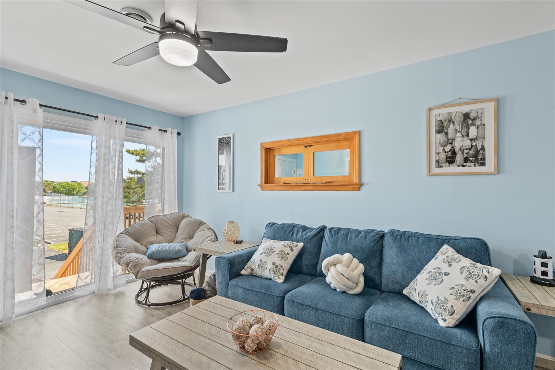 Decorative wooden frames and ocean-inspired decor bring a touch of coastal charm to the living room.