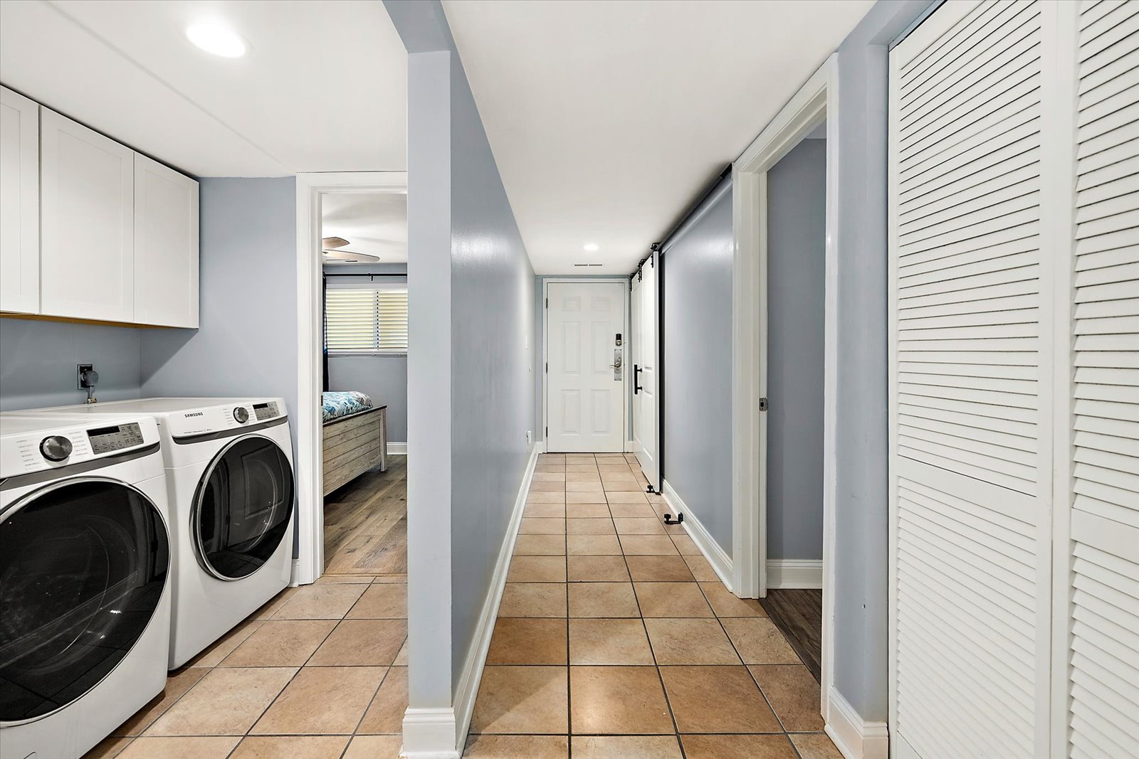 The central hallway features sleek tile flooring and convenient, easy access to an in-unit washer and dryer.