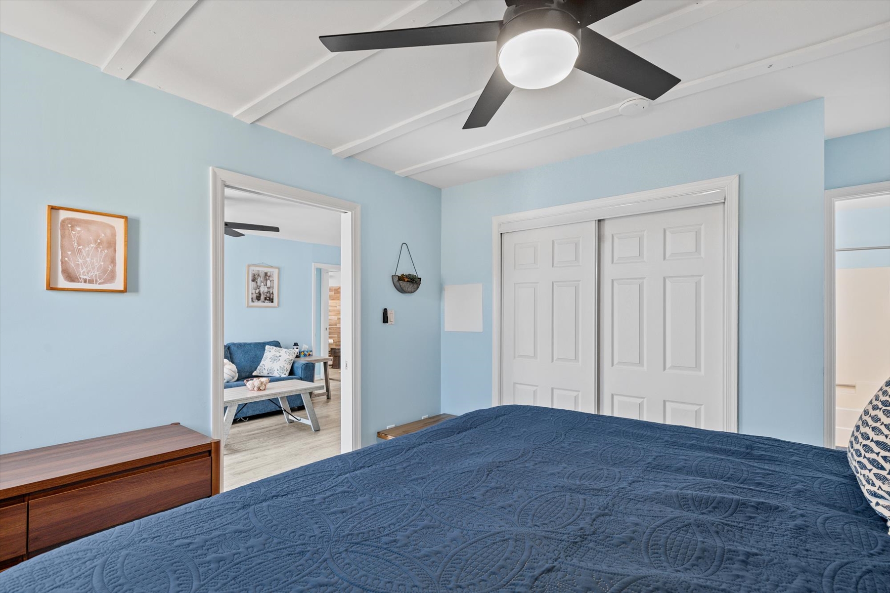 This bright bedroom angle highlights the unique paneled ceiling design and easy access to the main living areas.