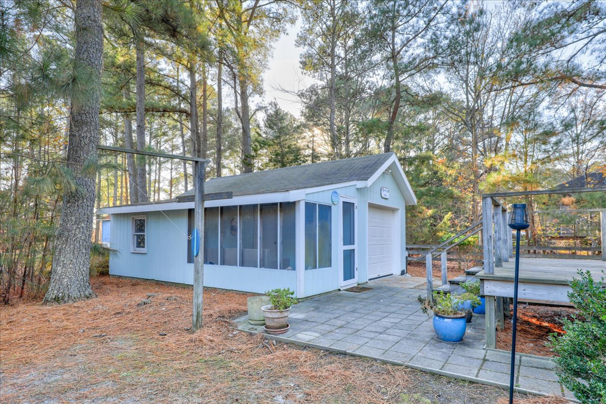Paved Patio off the Deck leads to the detached Screen Room and Garage.