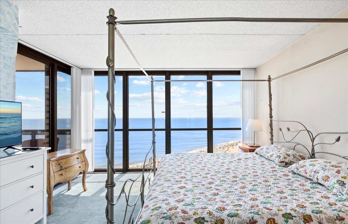 The Primary Bedroom offers a Plush King Bed and Private Balcony Access