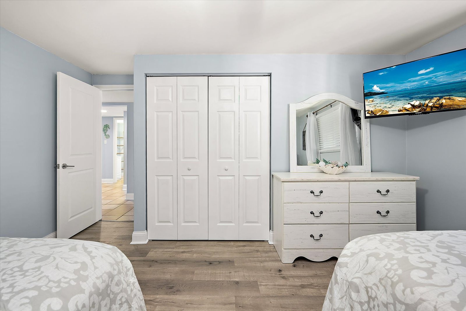 This bedroom features an expansive storage dresser with a mirror, a flatscreen TV, and a generous double-door closet for your vacation wardrobe.