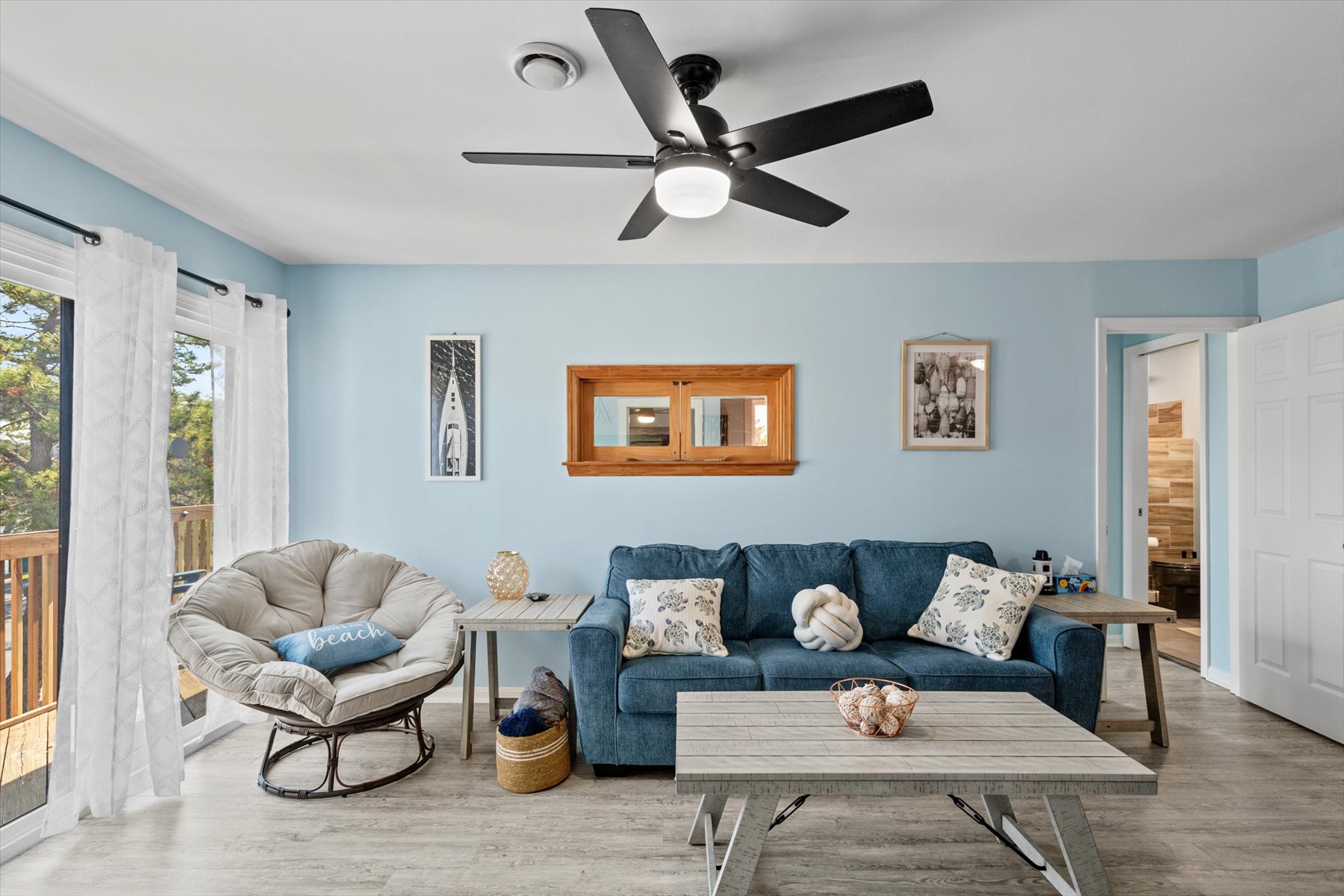Soft blue walls and a modern ceiling fan creates a cool, relaxing atmosphere throughout the main seating area.