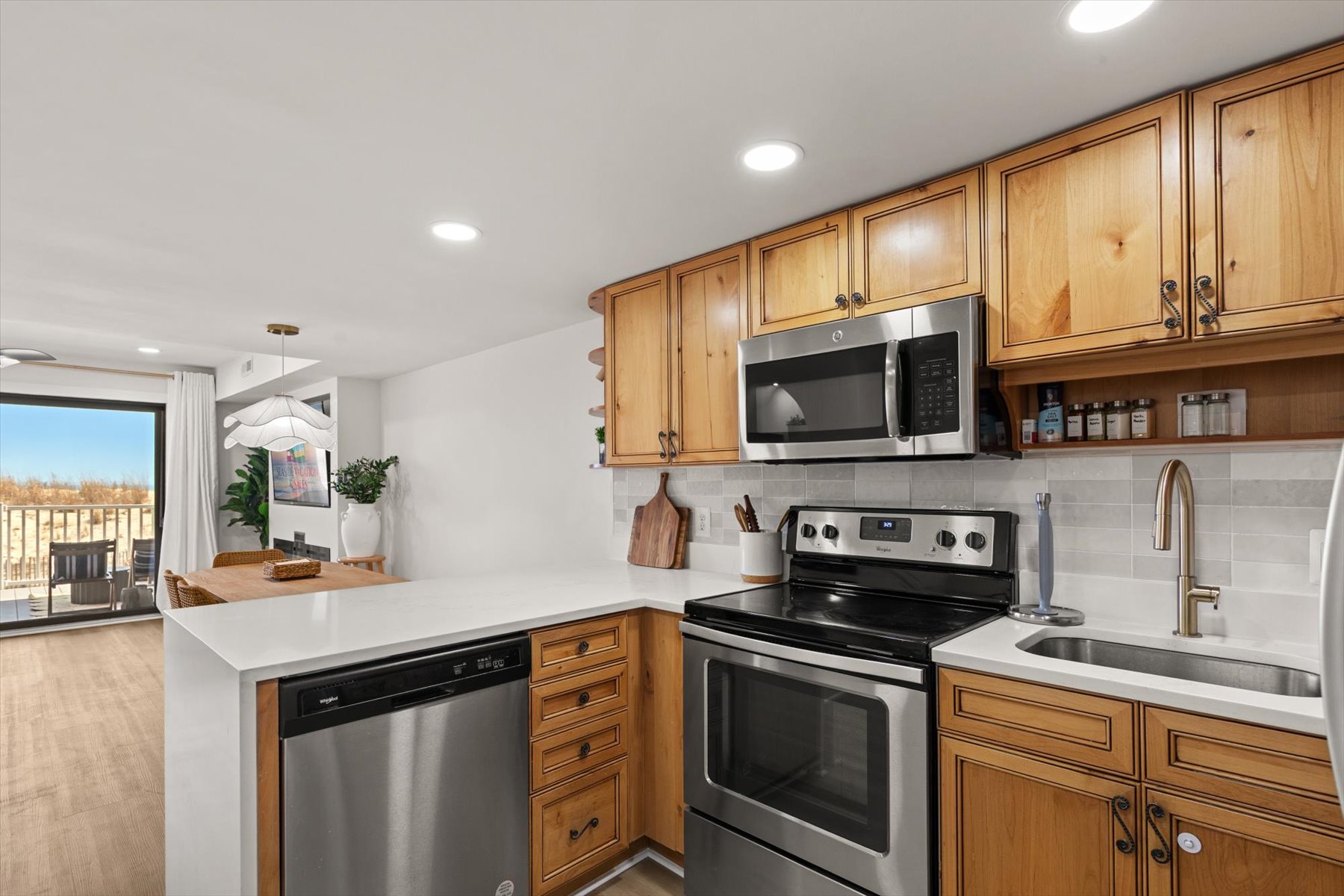 Sleek design with gleaming white counters and warm wood cabinetry.