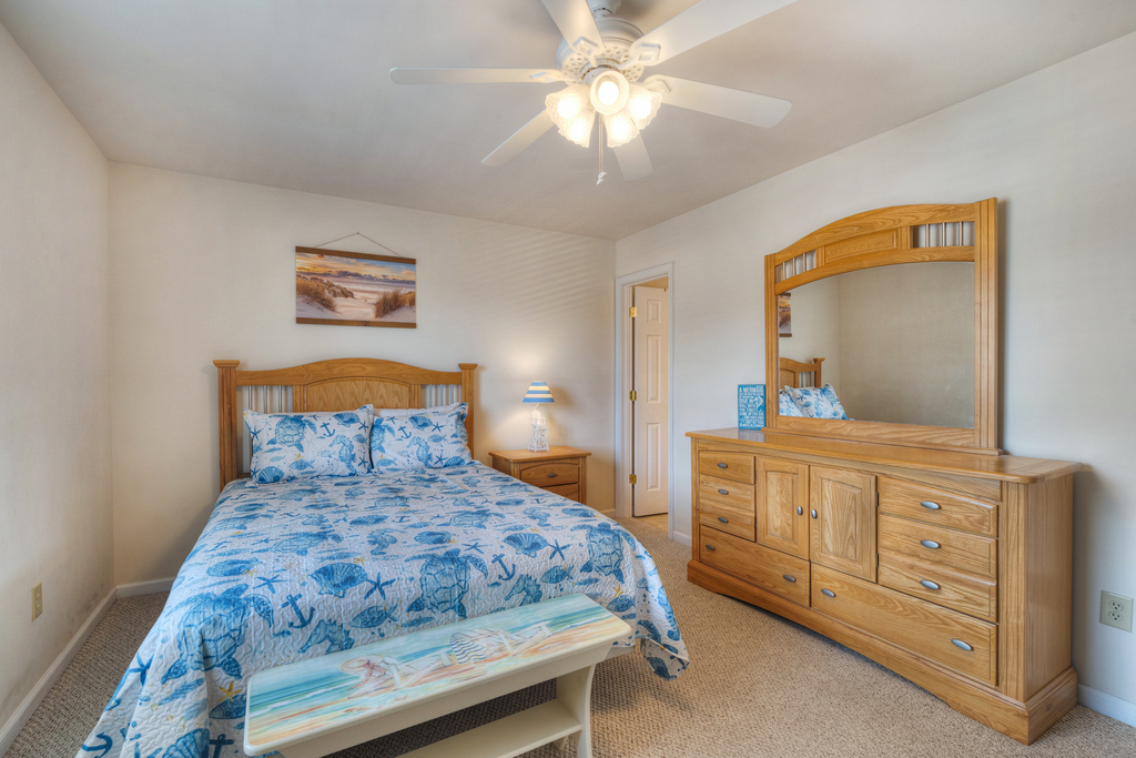Primary Bedroom has a comfy Queen Bed and is dressed in beachy blues and whites.