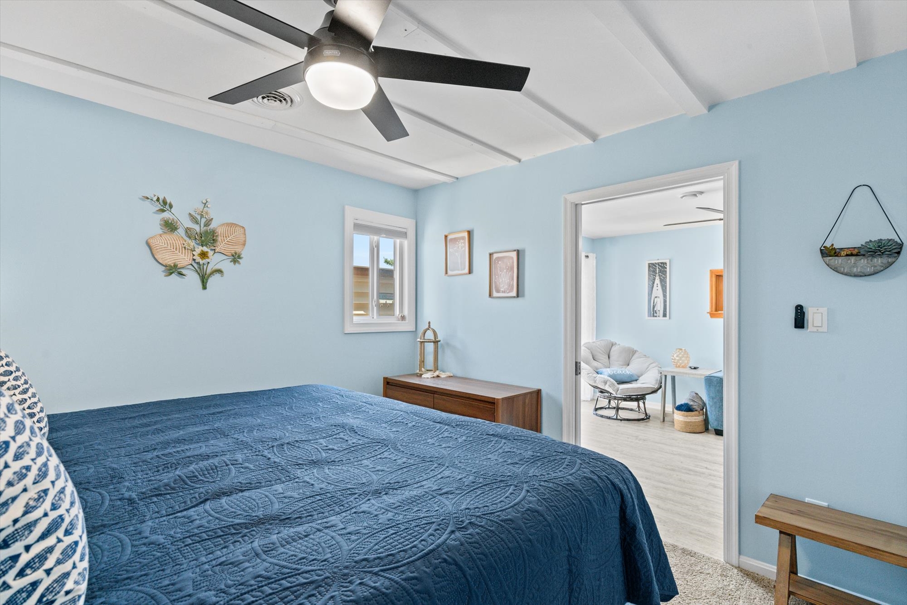A small window pulls in natural light, brightening up this serene bedroom and suite.