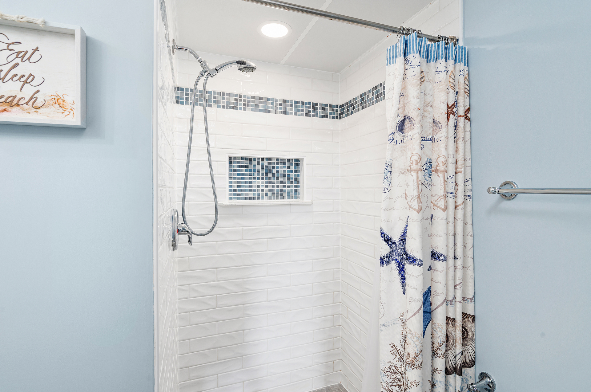 Wash away the Summer Sun in the Custom-Tile Walk-In Shower.