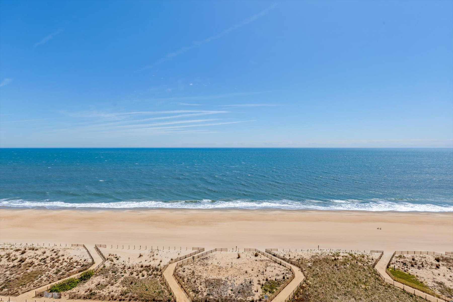 Look down onto the beautiful sand dunes and boardwalk paths leading directly to the shoreline.