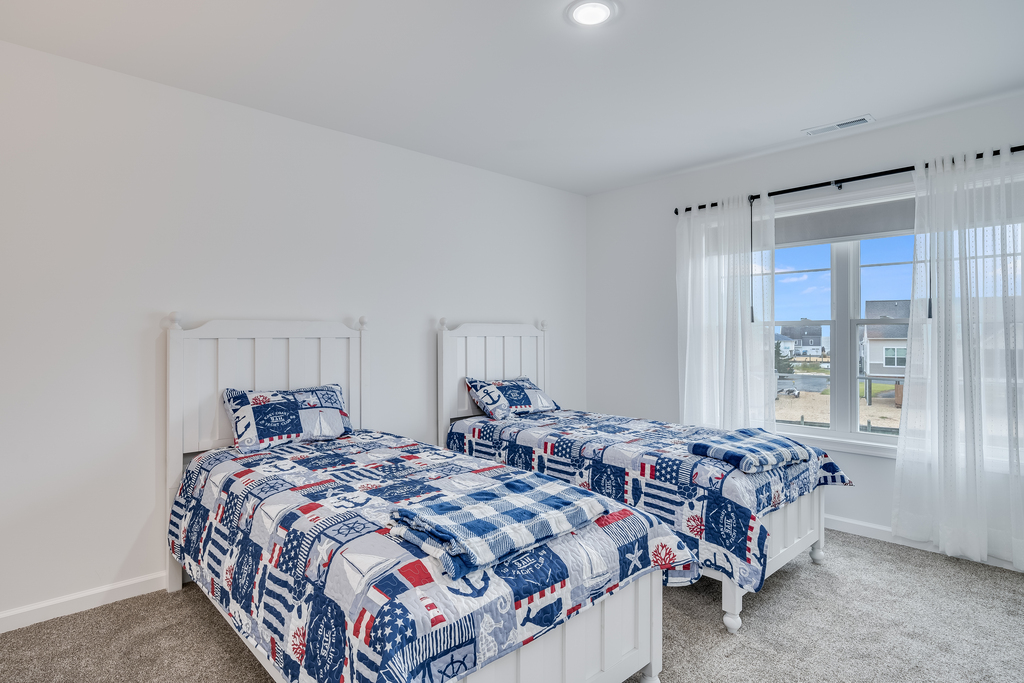 Bedroom 3 is adorned in Crisp White and Nautical Navy and has 2 Twin Beds.