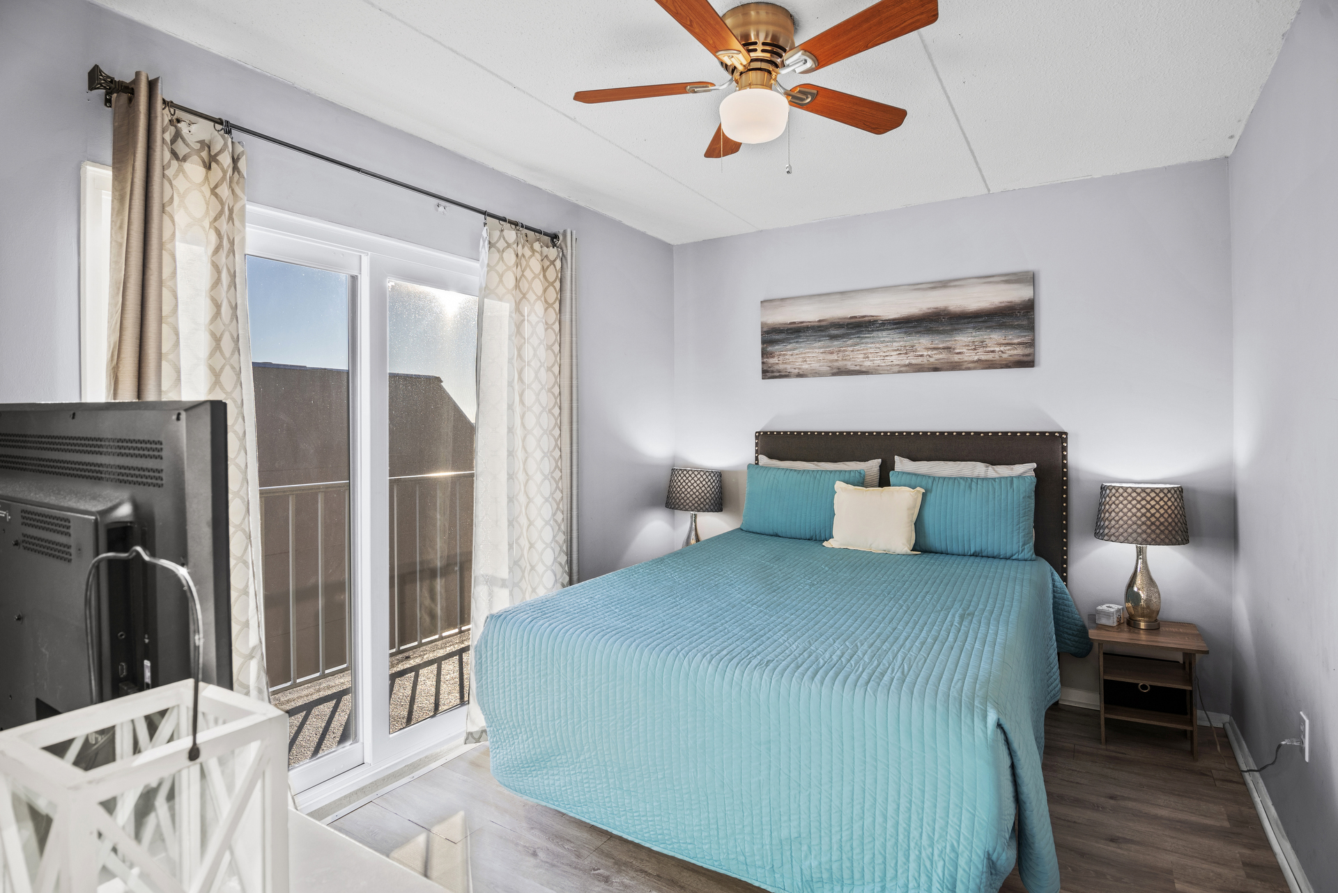 Lovely Bay View Primary Bedroom has a comfy Queen Bed, Flat Screen TV and Balcony Access.