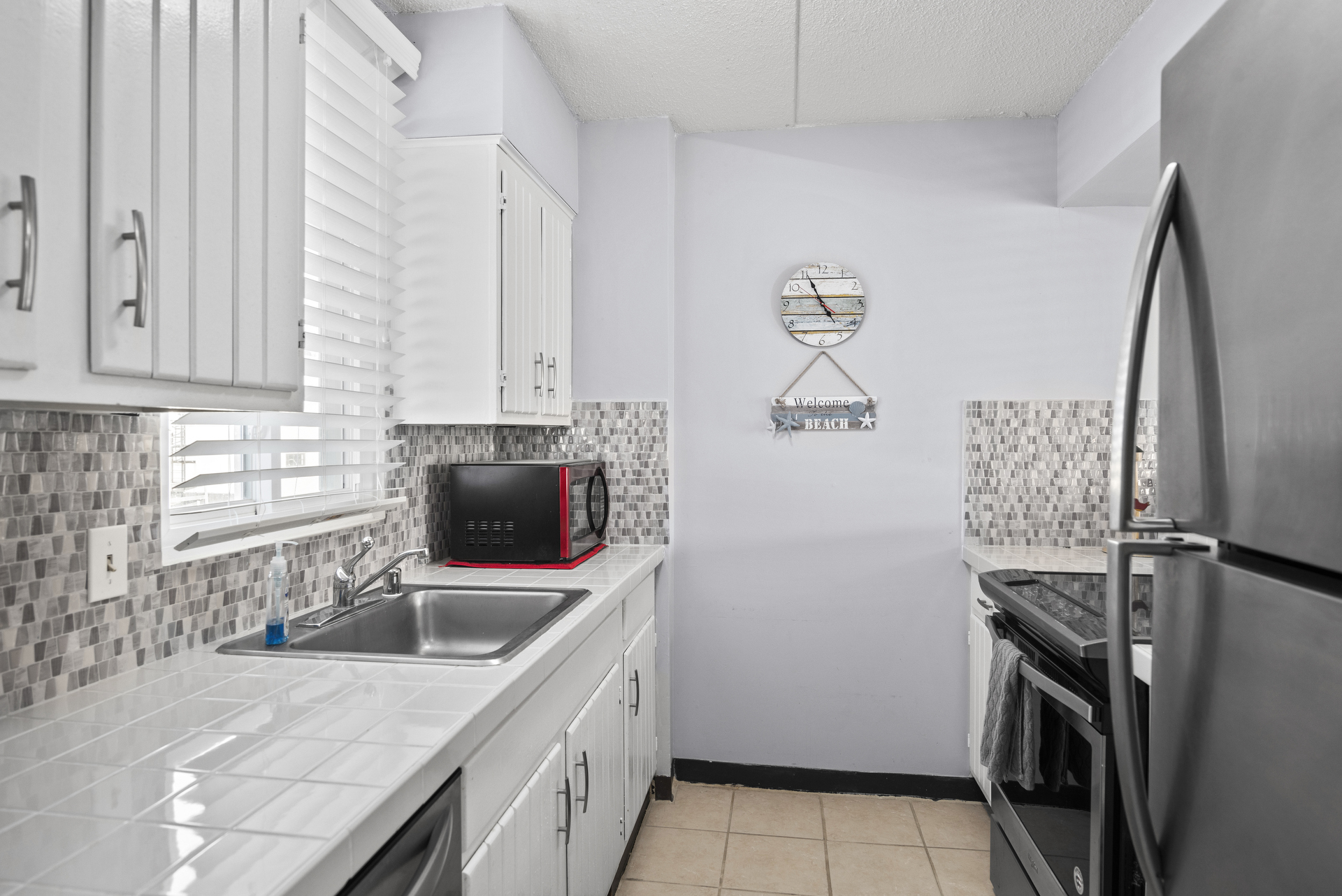 Kitchen has stunning Back Splash and cheerful pops of Nautical Red.