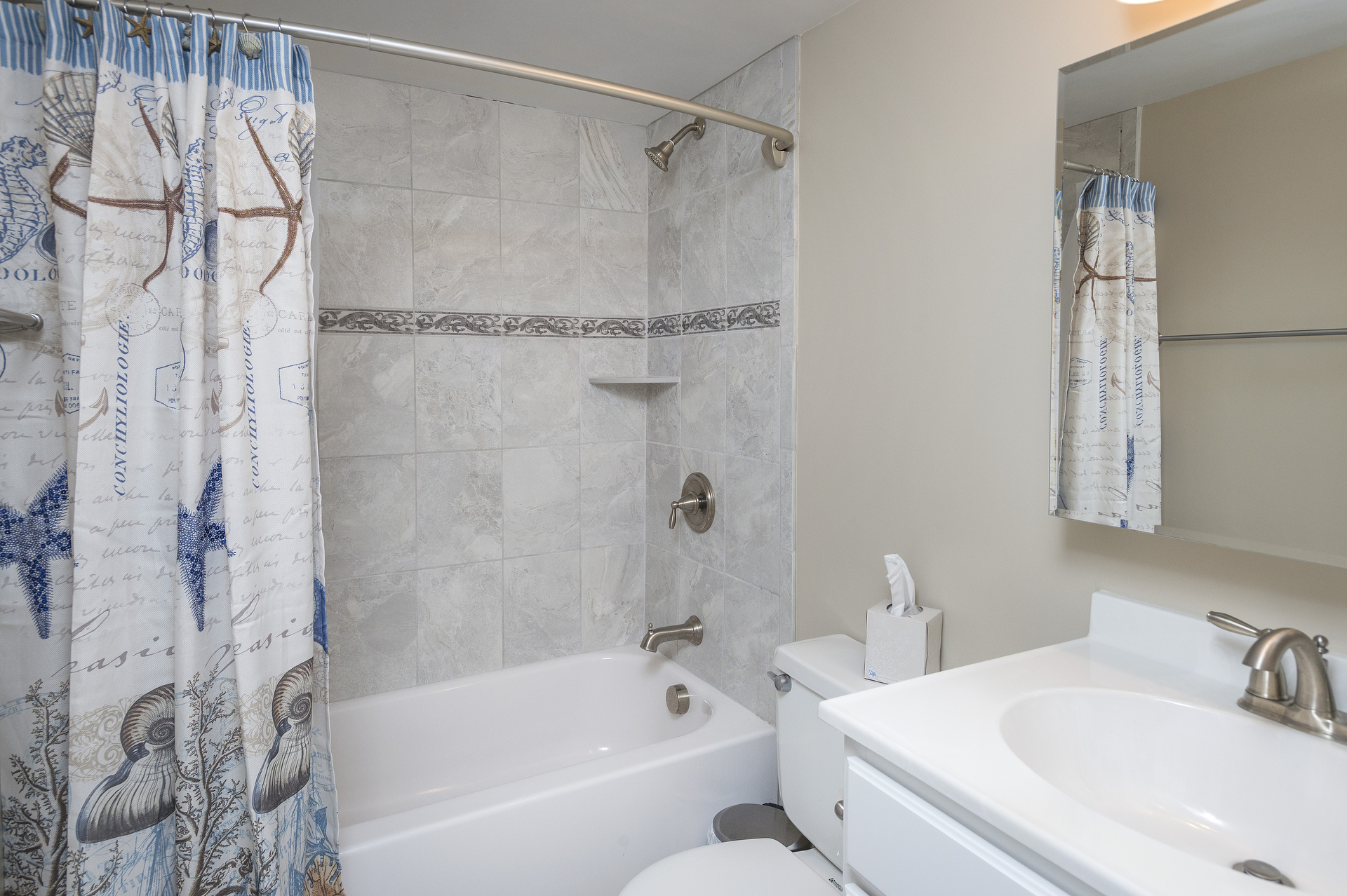 Lovely Full Bath with Custom Tile & Tub/Shower Combo is shared between Bedroom 2 & the Den