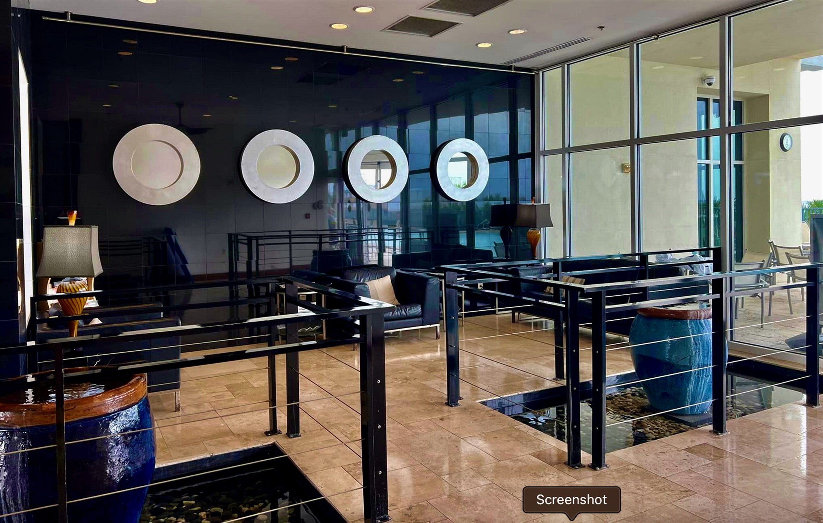 You'll find striking contemporary design in this modern lobby, featuring dramatic glass walls and artistic circular elements that create an impressive first impression.