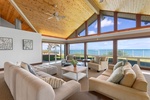 Sunlit living room with vaulted wood ceilings and sweeping Pacific vistas.