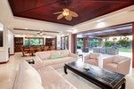 Spacious open-plan living room with vaulted ceilings, elegant wood accents, and seamless outdoor access.