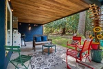 Unwind under the covered patio with cozy chairs, ambient lighting, and a propane BBQ for casual gatherings.