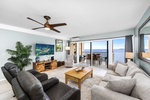 Air-conditioned living room with Smart TV, plush seating, and wall-to-wall ocean views.