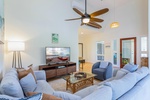 Airy living room with vaulted ceilings and lanai access.