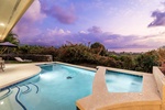 Heated pool and spa with a sunset backdrop, ideal for ultimate relaxation