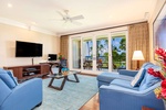 Bright living room with plush seating, pool views, and island-inspired décor.