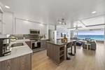 Your open-concept kitchen flows seamlessly into the living space, where ocean views greet you through expansive windows.