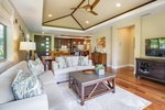 Gather in the open-concept living room, where vaulted ceilings and stylish island décor create an inviting retreat.